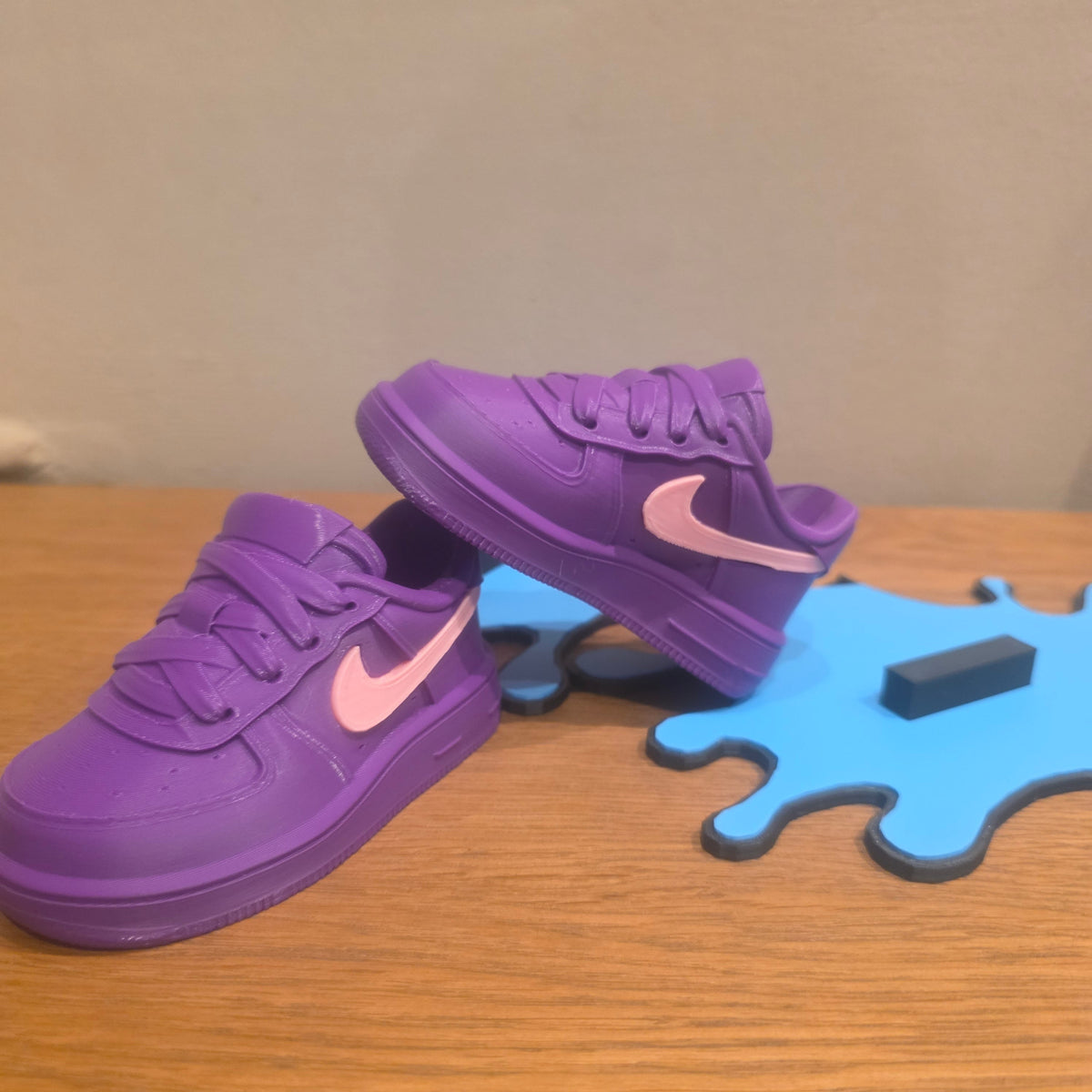 3DPrintingLabDesigns purple and pink sneaker-inspired PS5 controller stand on a blue drip-shaped base.