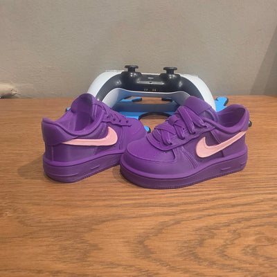3DPrintingLabDesigns purple and pink sneaker-inspired PS5 controller stand on a wooden desk