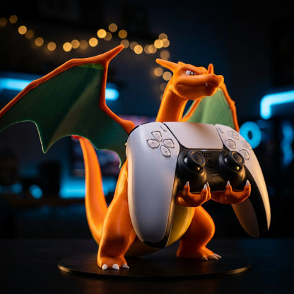 3D-printed Charizard figure in a PS5 controller holder pose, gripping a white DualSense controller in its claws, set against a dark background with blue neon lights and warm string lights.