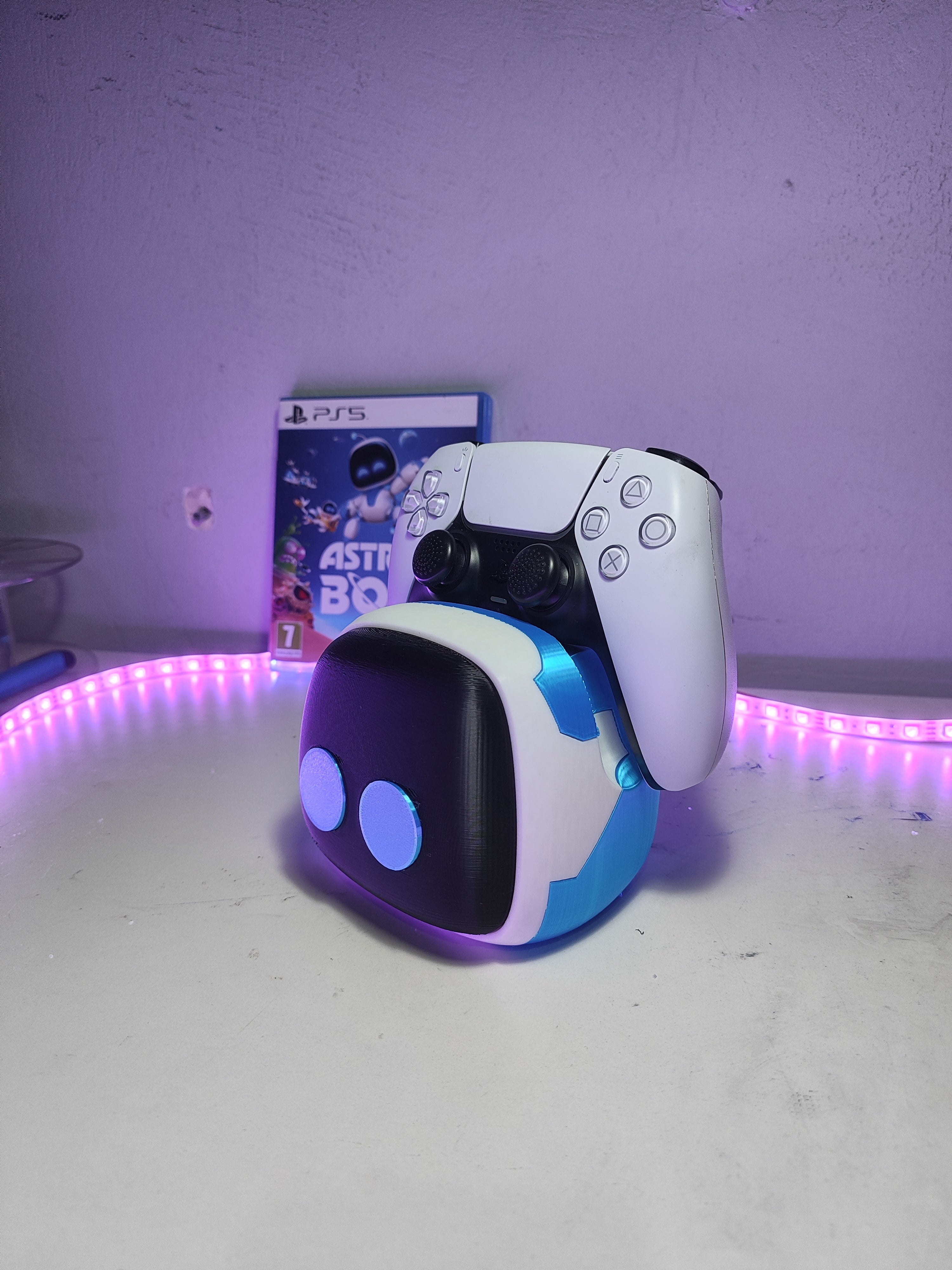 Astro Bot stand showcasing a PlayStation 5 DualSense controller on a desk