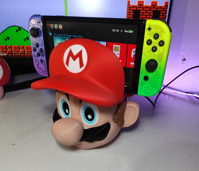 Super Mario head dock holding a Nintendo Switch with neon Joy-Cons on a desk setup