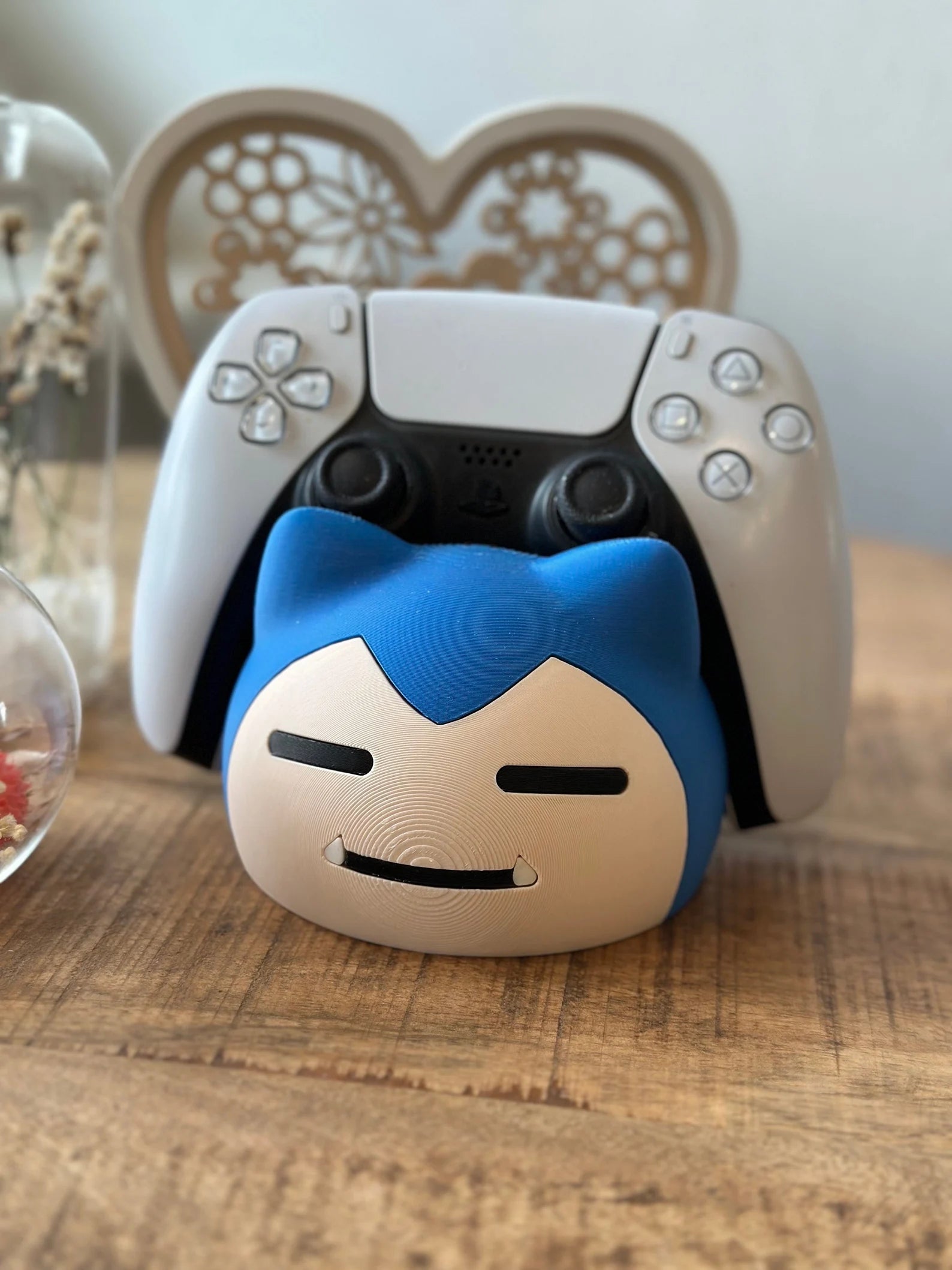 Snorlax controller holder with PlayStation 5 DualSense controller on wooden desk