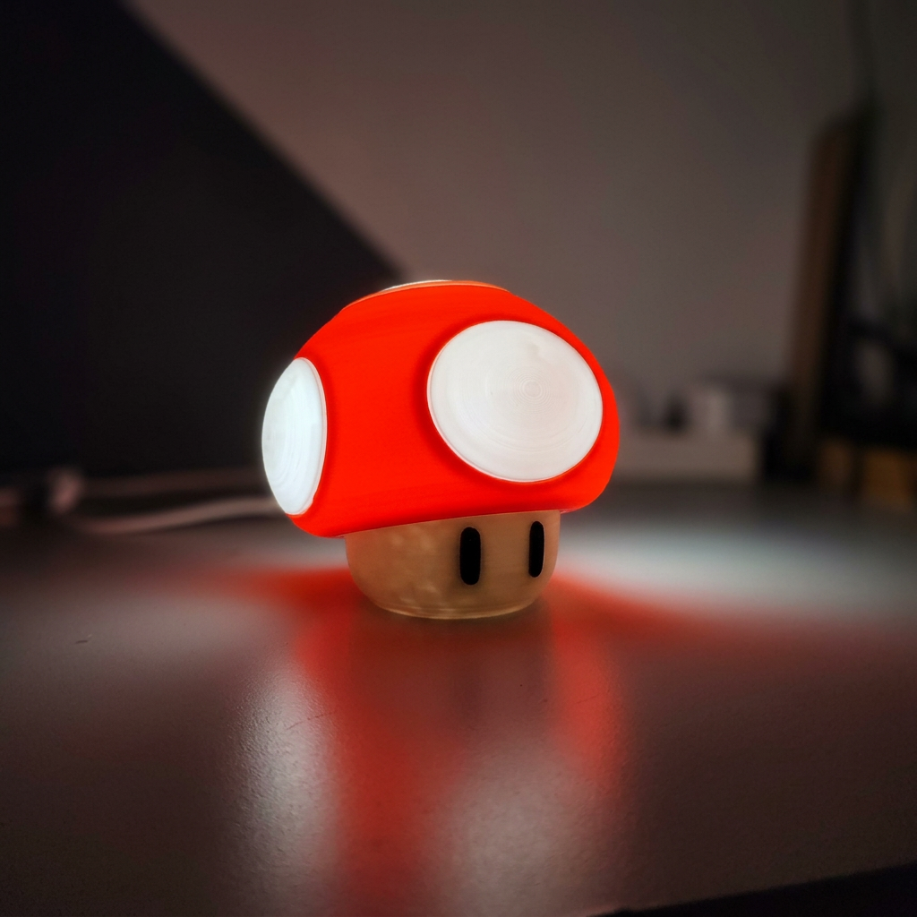 Red mushroom LED night light illuminated on a desk in a dim room